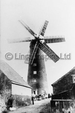 Waltham windmill with miller and family at the foot of the mill tower.